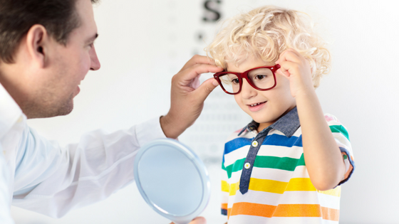 a man and a child with glasses looking at a mirror